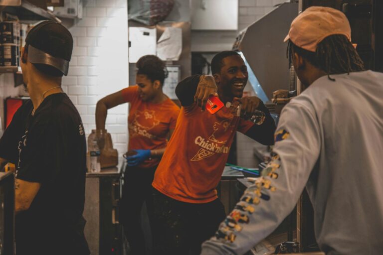 Energetic restaurant staff working together in a kitchen, showing teamwork and joy.